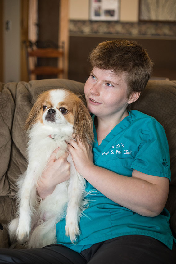 Photo of young girl with developmental disabilities holding a dog